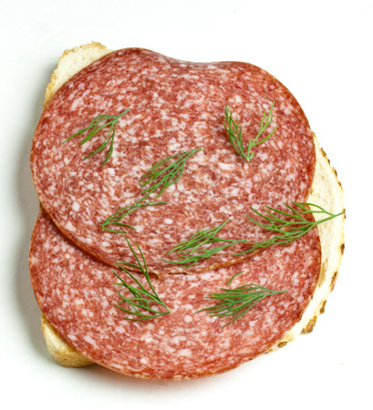Bread with salami on a white plateの写真素材