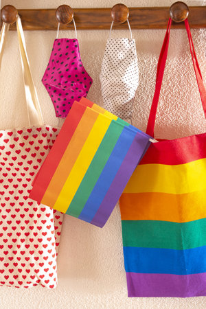 Close-up of various gay flags on a rainbow TV bag with various hygienic face masks. Concept of...