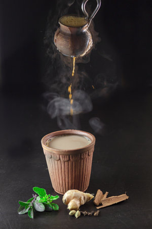 Hot Indian
 Tea is getting poured from mud pot to mud glassの写真素材