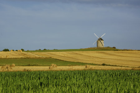 A beautiful view of a windmill on a farm field in Normandy, Franceの写真素材