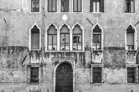 A grayscale shot of the ancient buildings with weathered exterior walls in Venice, Italyの写真素材