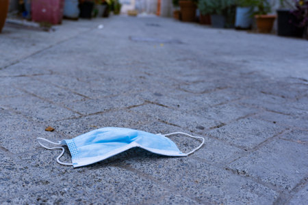 A used surgical mask on the ground in the street after the pandemicの写真素材
