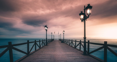A beautiful empty wooden pier on a tranquil sea during sunset