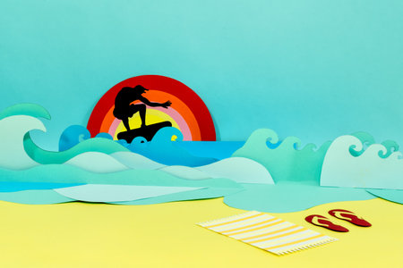 A creative paper craft of a surfer on the waves and a sandy beachの写真素材