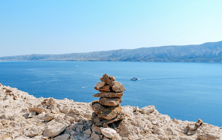 A scenic view of a stone cairn on a blue sky backgroundの写真素材