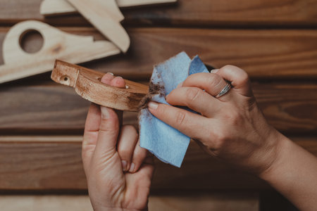 An overhead shot of woman's hands waxing wood as home carpentry activityの写真素材
