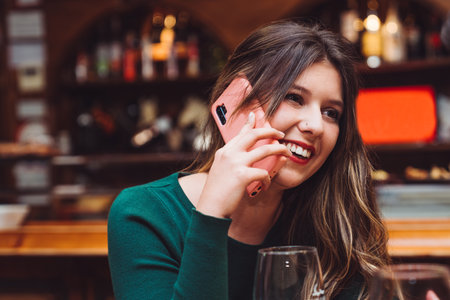 A young beautiful female talking on the phone and smilingの写真素材