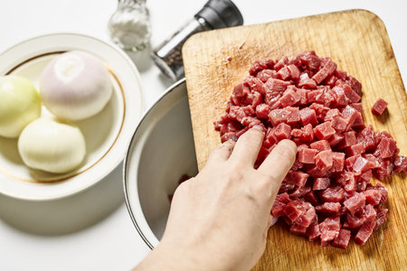 A person using ground meat, onions and seasonings for homemade manti dumplingsの写真素材