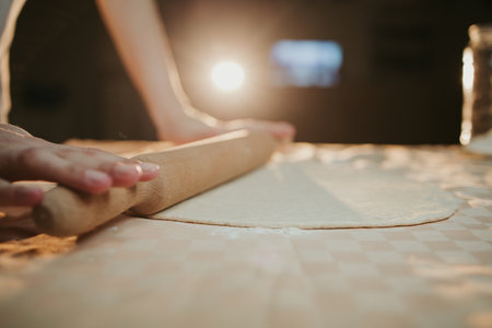 A closeup shot of a person preparing dough for pizza with a rolling pinの写真素材