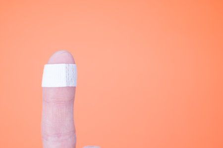 A closeup on a finger isolated on an orange backgroundの写真素材