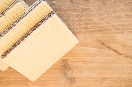 A top view of delicious crispy chocolate wafers on a wooden table