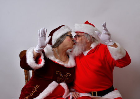 Lovely Mr and Mrs Santa Claus kissing and enjoying each other's companyの写真素材