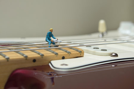 A closeup shot of a small figure of a person on an electric guitarの写真素材