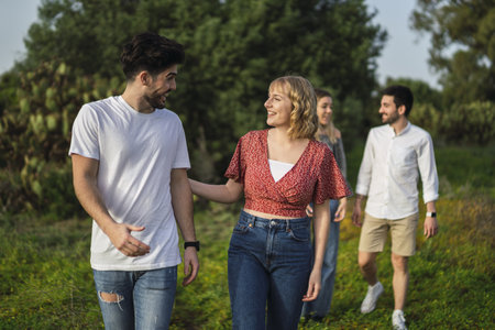A shallow focus shot of Spanish Caucasian young friends hanging out in a park, two couplesの写真素材