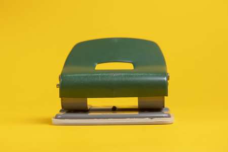 Frontal view of perforator office tool still life against a seamless solid yellow backgroundの写真素材