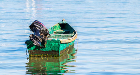 An old damaged boat sailing on the seaの写真素材
