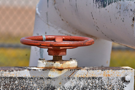 A large, red gang valve on an irrigation pipe system.