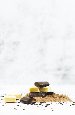 A vertical shot of dark and milk chocolate pieces on shaved chocolate powder with copy space aboveの写真素材