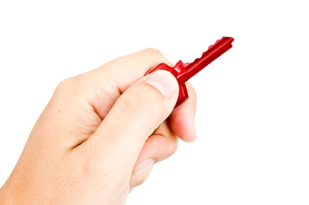 A man's hand with a red key against the white background