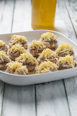 A vertical shot of stuffed mushrooms with bacon and grated cheese on a plaの写真素材