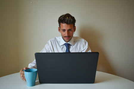 A shallow focus of a Caucasian businessman working from home on his laptopの写真素材
