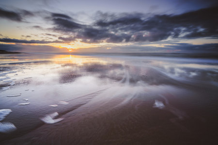 Maritime landscape at sunset with reflection of clouds in low tide water, Waddenzee, Texel, The Netherlandsの写真素材