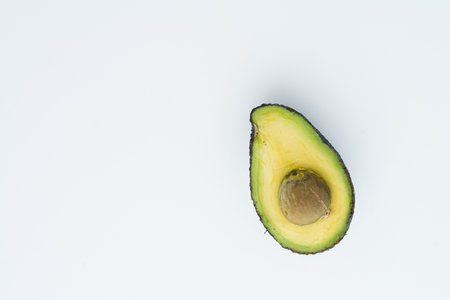 A top view of the half of an avocado with a seed inside isolated on a white backgroundの写真素材