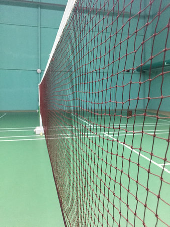 A vertical shot of the net of an empty indoor badminton courtの写真素材