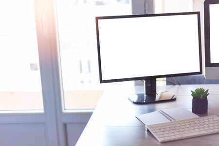 A workplace with a computer, keyboard in front of the window