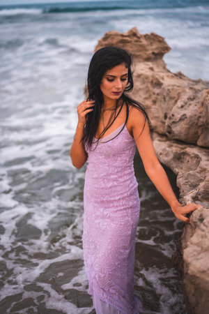 A young brunette Caucasian woman in a purple dress posing in the water in Cabo de Gata beach, Spainの写真素材