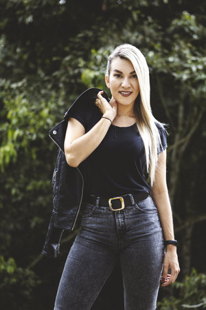 A vertical shot of a blonde Hispanic female posing in a parkの写真素材