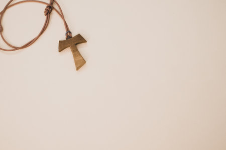 A top view of a wooden tau cross necklace isolated on a white backgroundの写真素材