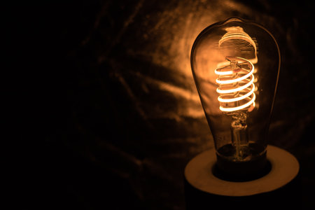 A scary, mysterious cave-like room with a single lightbulb illuminating the darknessの写真素材