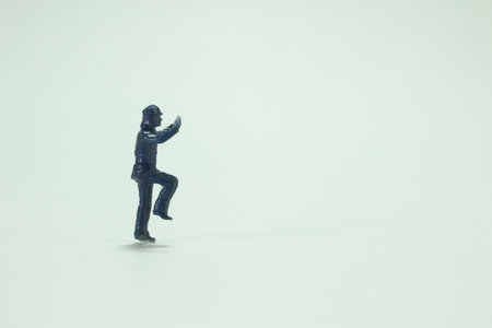 A minifigure of a person standing on one leg with raised arms /miniature peopleの写真素材