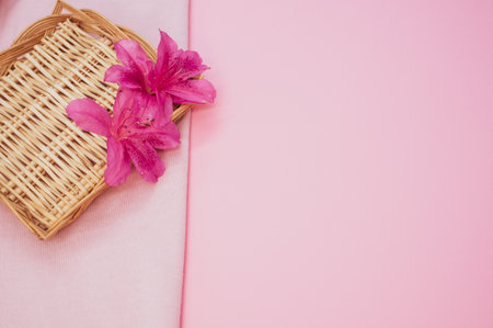 Beautiful pink lilies on a straw texture isolated on a pink backgroundの写真素材