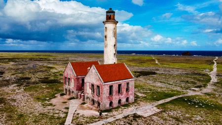 An aerial top view of an old abandoned lighthouse under a beautiful cloudscape in Little Curacao uninhabited islandの写真素材