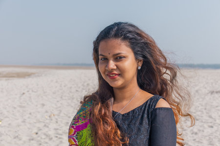 A portrait of a smiling Indian female with a colorful scarf outdoorsの写真素材