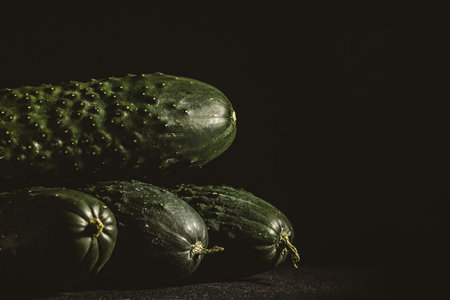 Ripe cucumbers on a dark backgroundの写真素材