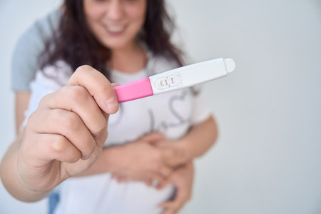 heterosexual couple embracing show the camera a pregnancy test. the test is positive. selective focusの写真素材