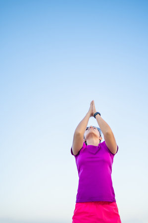 A vertical shot of a Hispanic woman doing yoga outsideの写真素材