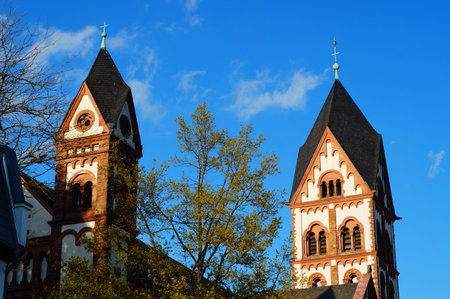Two towers of the Catholic St. Joseph's Church in Frankfurt-Eschersheim in the evening light against a blue sky.の写真素材