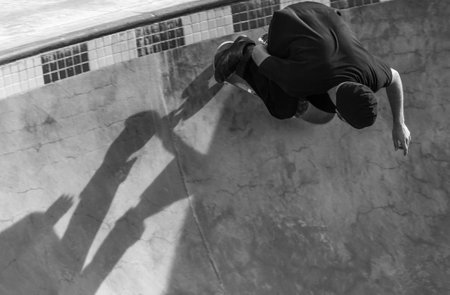 A grayscale shot of a person skating in a skatepark