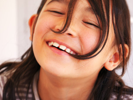 A closeup shot of a smiling french girl with brown hairの写真素材