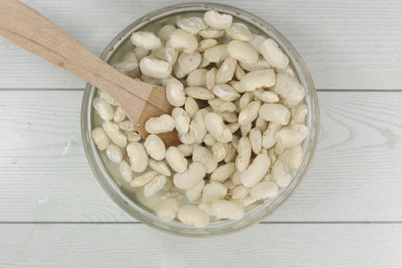 A top view of big white beans soaking in a bowlの写真素材