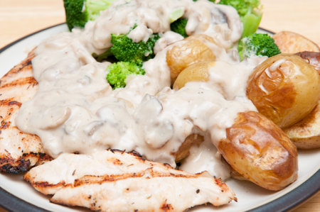 A closeup shot of chicken slices ith potatoes and mushroom creamの写真素材