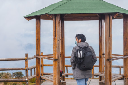 A young guy hiking in mountains and enjoying the beautiful viewの写真素材