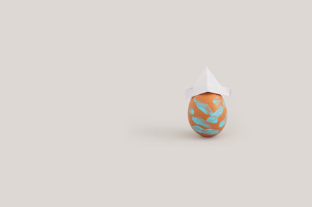 The decorated funny Easter egg in the gray background with copy space on the leftの写真素材