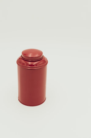 A vertical shot of a red metal container on a white background