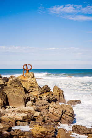 A vertical shot of the "Peine del Viento" sculptures of Eduardo Chillida at the beach in Spainの写真素材