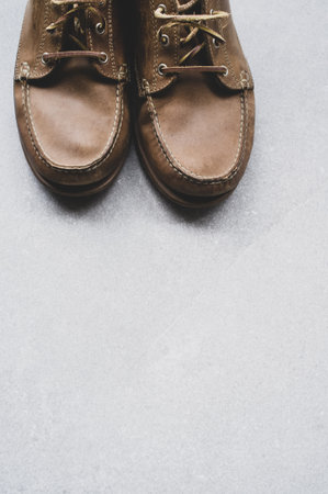 A vertical shot of comfortable brown shoes on a gray surfaceの写真素材